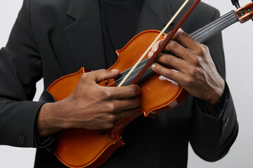 Closeup of a man in a suit playing the violin gracefully on a plain white background