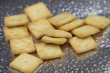 Salty crackers on a silver textured background