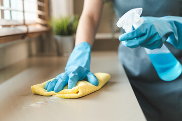 Housekeeper doing chores concept, Close-Up view of housemaid cleaning furniture surface with...