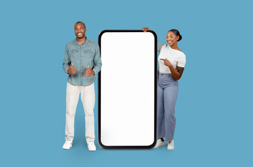 Happy man and woman by giant smartphone mock