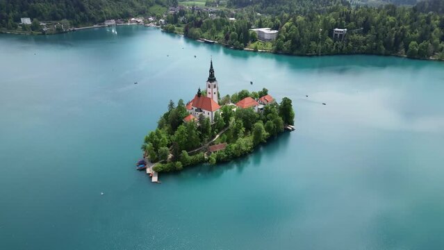 Aerial around view Pilgrimage Church of the Assumption of Maria on a small island, Bled lake, Slovenia, 4k