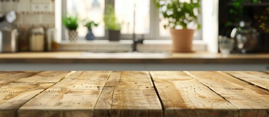 Wooden table with no items on it and a blurred background of a kitchen counter. - obrazy, fototapety, plakaty