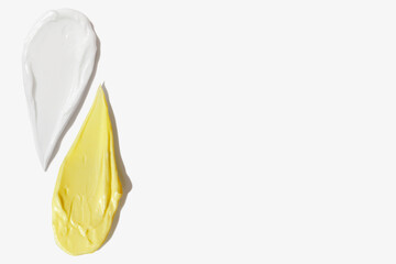 Yellow and white cream smears on empty background
