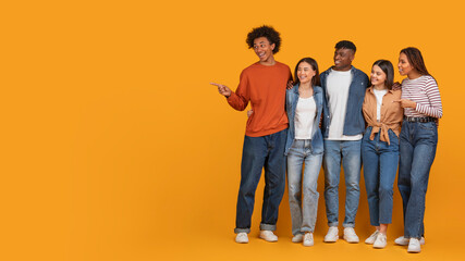 Group of young people smiling and pointing right