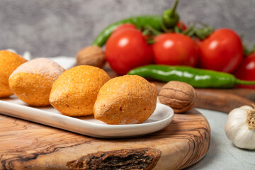 Uncooked frozen stuffed meatballs. Kibbeh or kibbeh on a wooden serving board. Close up