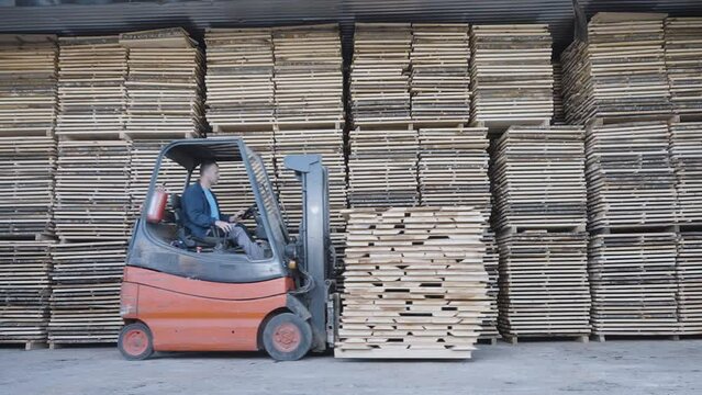Skillful worker drives forklift in the factory