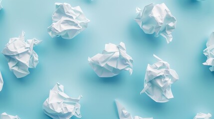 Fototapeta premium Several pieces of white crumpled paper dramatically highlighted on a pastel blue background, emphasizing themes of renewal and the creative reuse of materials