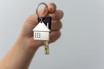 Person holding key with house keychain, ready to unlock car alarm