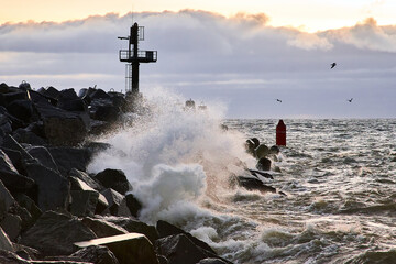 Seascape with a breakwater and a view of the water. Strong waves break against a protective...