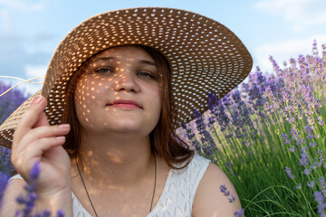 Happy woman in sun hat among purple flowers, wearing eyewear