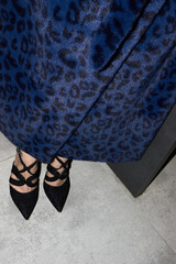 a girl in a blue leopard fur coat and stiletto heels .Close-up