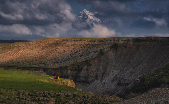 Picnic near Natural landscape with snowy mountain in the background and valley in the foreground, meadows on the plain and clouds floating in the sky. Ugam ridge in Southern Kazakhstan