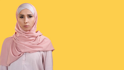 Female portrait. Serious face. Confident strict angry dissatisfied woman in hijab frowning isolated on yellow empty space background. - 790980756