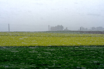 Blurry snow with agriculture field and gray sky background at Swiss village of Dinhard. Photo taken April 21st, 2024, Dinhard, Canton Zürich, Switzerland.