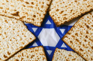 Matzo, an unleavened flatbread, arranged around a blue and white Star of David. The star is prominent, symbolizing Jewish identity and heritage, making this image representative of jewish passover