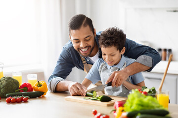 Father and son cooking together at home