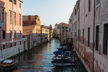 Fototapeta na wymiar Panoramic view of a water channel in city of Venice, Veneto, Italy, Europe. Venetian architectural landmarks and old houses facades along the man made water traffic corridor. Urban tourism in summer
