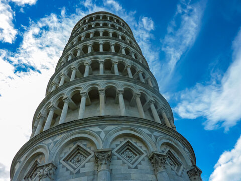 Scenic view of Leaning tower of Pisa and the Baptistry and Duomo seen from Piazza dei Miracoli, Pisa, Tuscany, Italy, Europe. Nearly four degree lean. Partially cloudy day in summer. Sightseeing