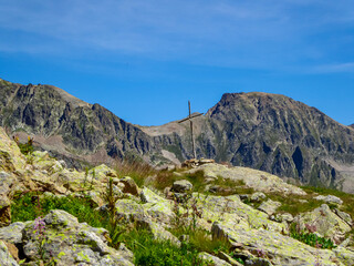 Summit cross with scenic view of the mountain range near Santuario Sant'Anna di Vinadio in provincia di Cuneo, Piemonte, Italy, Europe. Hiking trails in the Italian Alps. Tranquil atmosphere high up