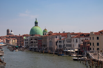 Panoramic view of the Grand Canal in city of Venice, Veneto, Italy, Europe. Famous landmark cathedral Santa Maria Della Salute along the water traffic corridor Grand Canale. Urban tourism in summer - obrazy, fototapety, plakaty