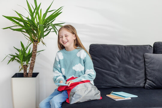 Morning preparation before school. Laughing Child with Book and Backpack at Home. Back to school.
