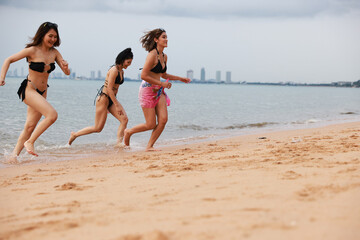 group of happy pretty women in bikinis  Ran up from the sea Holiday Vacation and  having fun