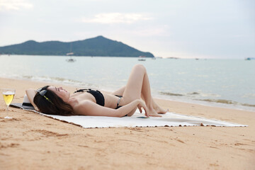 A young woman lies in summer on the beach, happy summer vacation