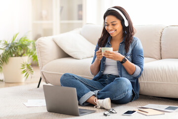 Woman Sitting on Floor Using Laptop, Drinking Coffee