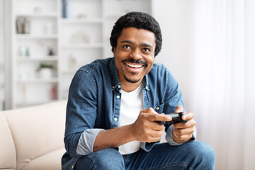 Man with a game controller grinning widely