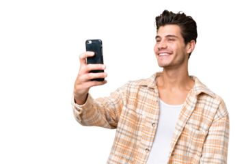 Young handsome caucasian man over isolated background making a selfie
