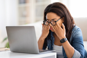 Tired African American Woman Wearing Glasses Looking at Laptop