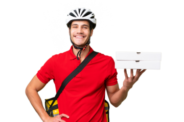 Pizza delivery man with work uniform picking up pizza boxes over isolated background posing with arms at hip and smiling