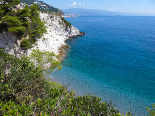 Scenic view of hidden beach of Spiaggia lido delle sirene along the Ligurian coast in Italy, Europe. Beautiful coastline of the Adriatic Mediterranean sea in summer. Clear clean turquoise water