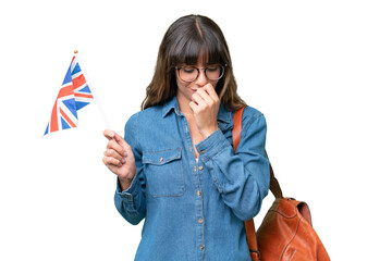 Young caucasian woman holding an United Kingdom flag over isolated background having doubts