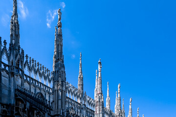 External view of Milan Cathedral (Duomo di Milano) from the rooftop, Milan, Lombardy, Italy, Europe. Historical marble facade with spires. Gothic architecture features. City travel tourism - obrazy, fototapety, plakaty