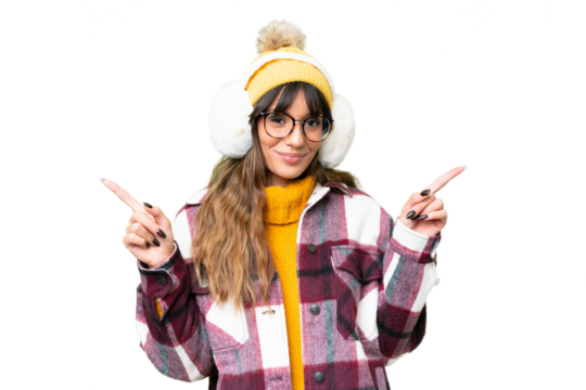 Young caucasian woman wearing winter muffs over isolated chroma key background pointing finger to the laterals and happy