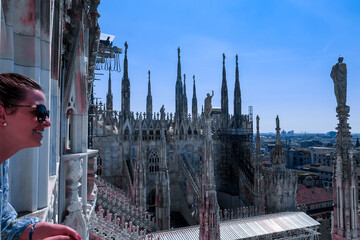 Female tourist with external view of Milan Cathedral (Duomo di Milano) from the Piazza del Duomo,...