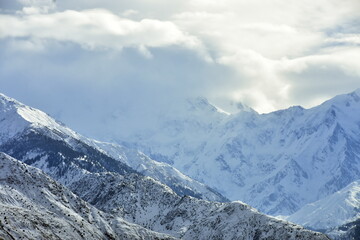 Breathtaking view of snow-covered mountains under a cloudy sky - Powered by Adobe