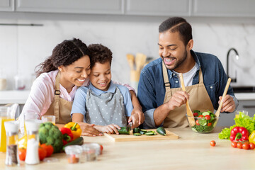 African American family working together in kitchen