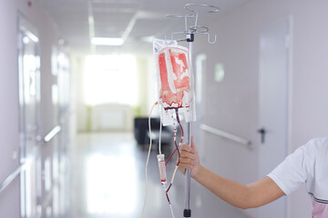 doctor holding blood transfusion machine in hospital
