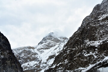 Snow-capped mountain peak amongst rugged cliffs