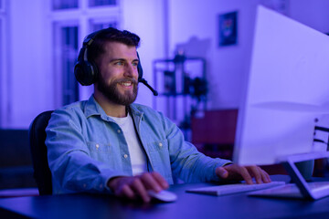Man with a headset gaming on a computer