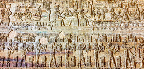 A Panel depicting a bas relief of procession of gods of ancient egypt on the walls in the Temple of...