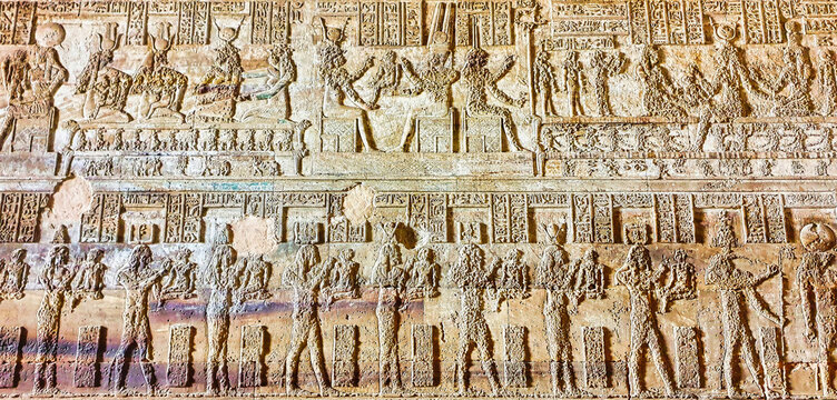 A Panel depicting a bas relief of procession of gods of ancient egypt on the walls in the Temple of Hathor at Dendera completed in the Ptolemaic era around 50 BC between Luxor and Abydos towns,Egypt