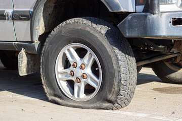 Fototapeta na wymiar A flat tire on road side, car wheel stuck, needs repair