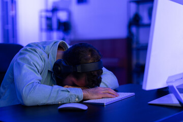 Exhausted gamer asleep on the keyboard at home