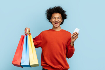 Excited shopper with a phone and colorful bags