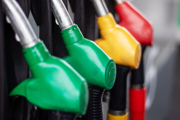 A collection of gas pumps in electric blue, plastic, carmine, and wire