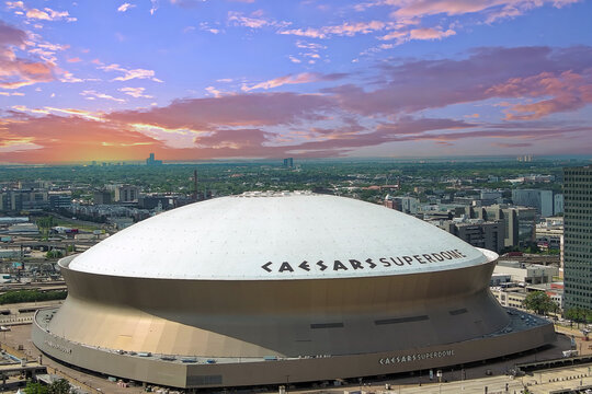 aerial shot of the Caesars Superdome with skyscrapers, office buildings and hotels in the city skyline and cars on the street in New Orleans Louisiana USA