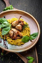 Quail with homemade noodles. Menu for a pub on a dark background. Colorful juicy food photography.